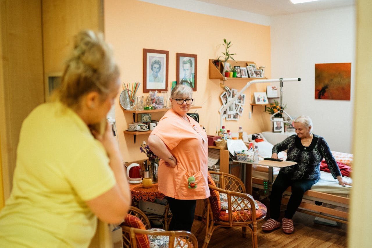 Caregivers interacting with a senior woman in a cozy retirement home in Karviná, Czech Republic.